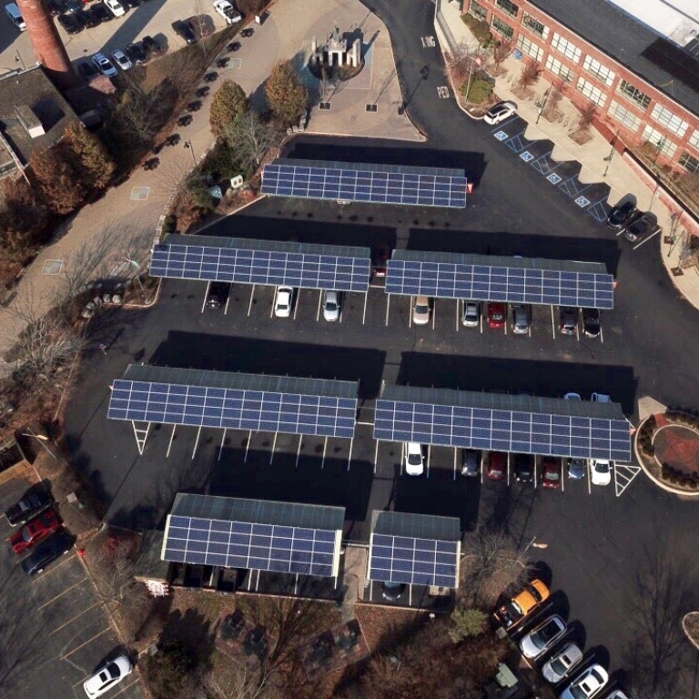 An aerial view of solar panels in a parking lot