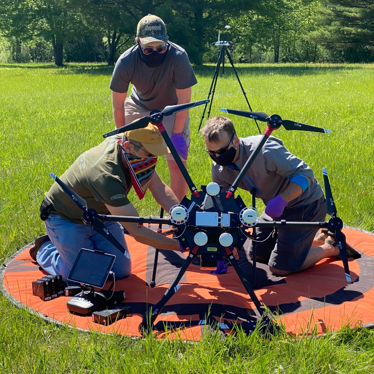 Researchers adjusting the drone