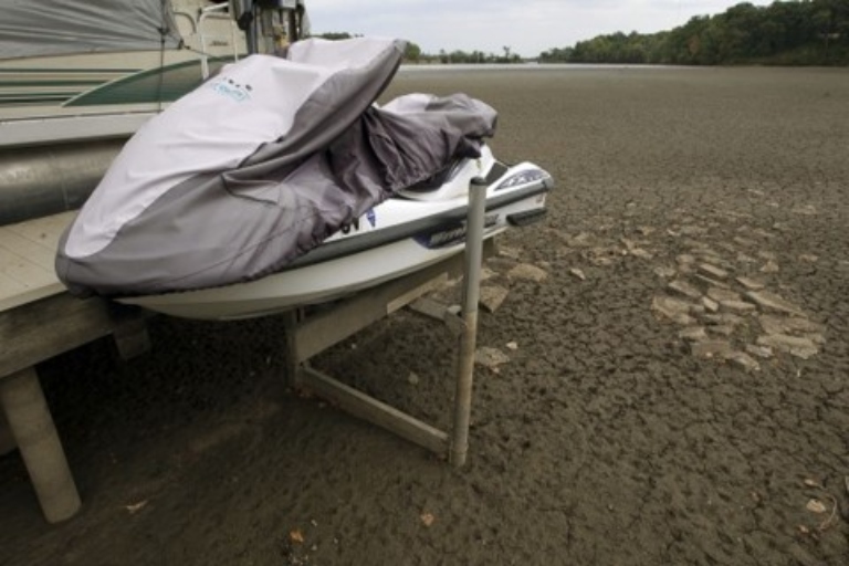 A jet ski in its dock over a dried-up lake bed