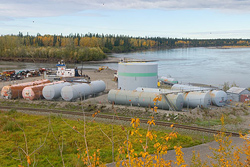 a waste plant with multiple cylindrical tubes next to a body of water