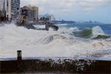 waves crashing over the boundary between land and see and going into the city