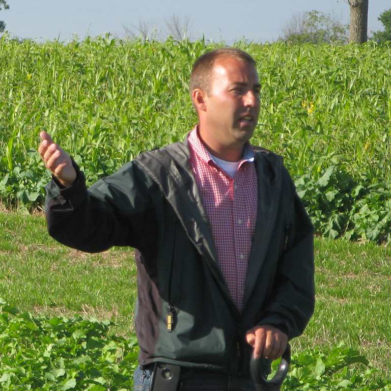 Jamie Scott speaking in front of a crop field